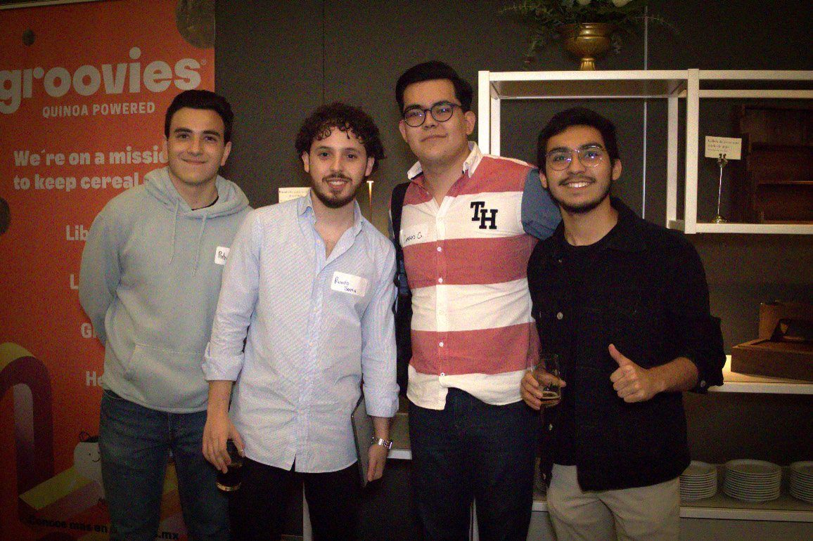 Four people standing together at an evening gathering.